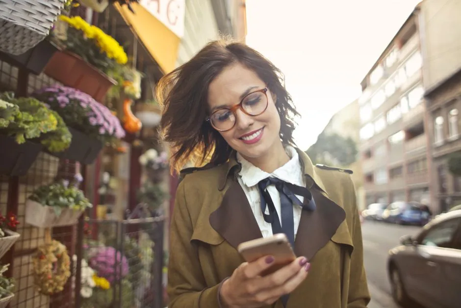 Mulher pesquisando no celular em uma rua com comércio